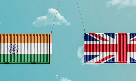 United Kingdom (UK) and India flags painted on containers hanging in a sky. Concept of business and trade between the UK and India