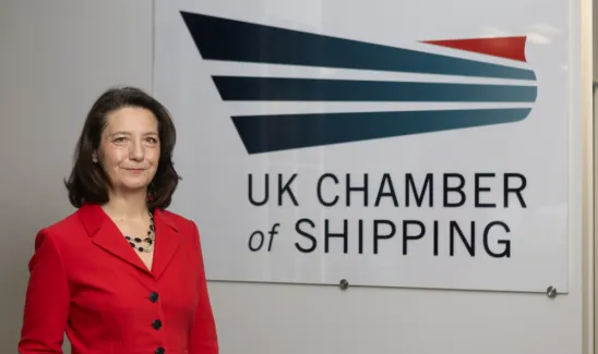 Karrie Trauth stands in front of UK Chamber logo